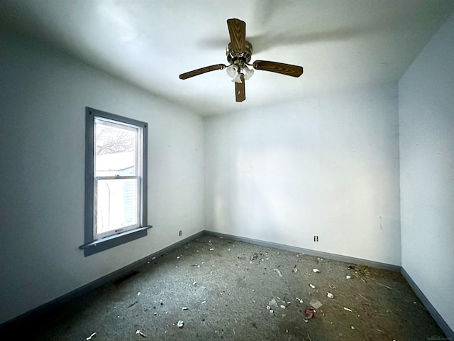 spare room with ceiling fan and baseboards