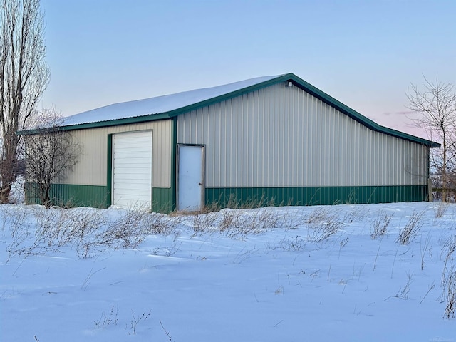 snow covered garage featuring a garage