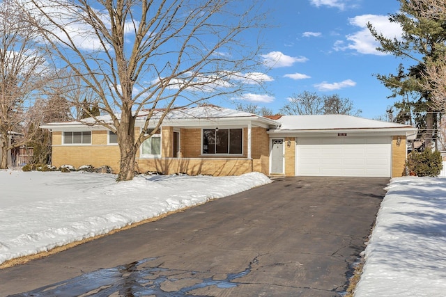 ranch-style home with a garage, driveway, and brick siding