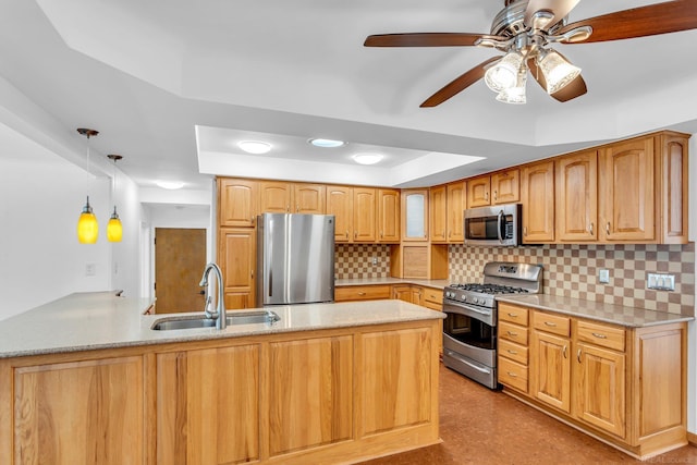 kitchen featuring stainless steel appliances, a raised ceiling, hanging light fixtures, a sink, and a peninsula