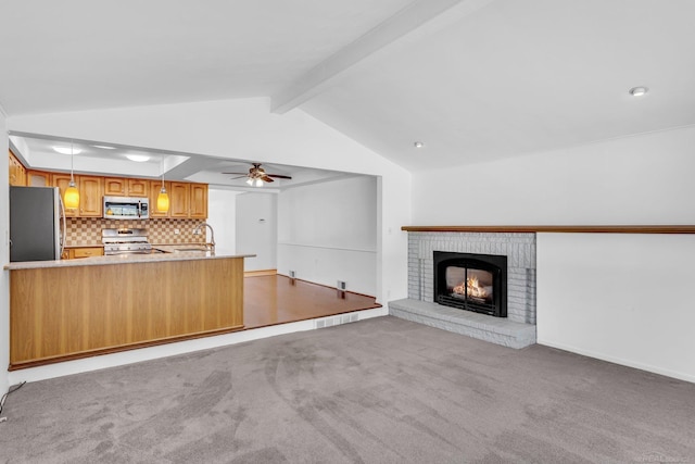 unfurnished living room with vaulted ceiling with beams, carpet floors, a sink, a ceiling fan, and a brick fireplace