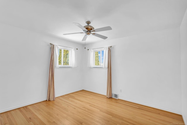 unfurnished room with light wood finished floors, baseboards, visible vents, and ceiling fan