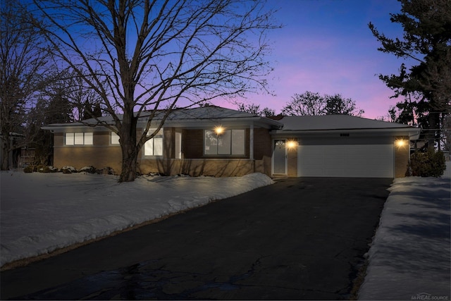 view of front of property with driveway, brick siding, and an attached garage