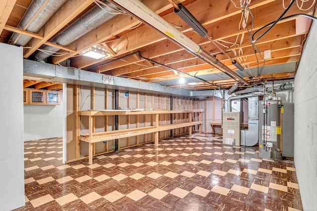 unfinished below grade area with heating unit, gas water heater, and tile patterned floors