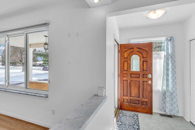 entryway with visible vents, baseboards, and light tile patterned floors