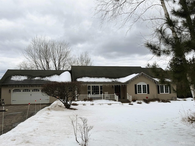 single story home featuring a porch and a detached garage