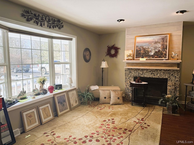 sitting room with a fireplace and wood finished floors