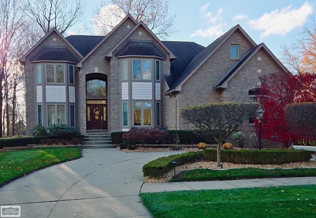 view of front of property featuring brick siding and a front lawn