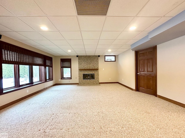 unfurnished living room with carpet floors, a tiled fireplace, visible vents, and baseboards