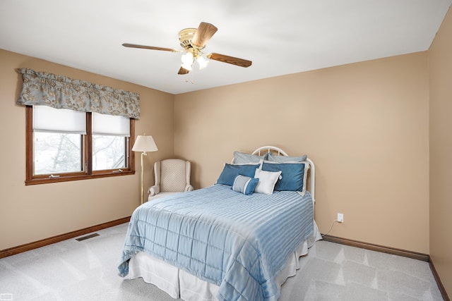 bedroom with baseboards, a ceiling fan, visible vents, and light colored carpet