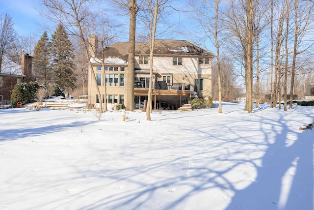 snow covered property with stairs and a wooden deck