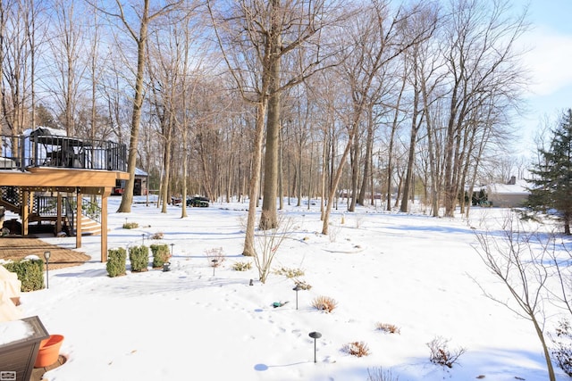 yard layered in snow featuring a deck