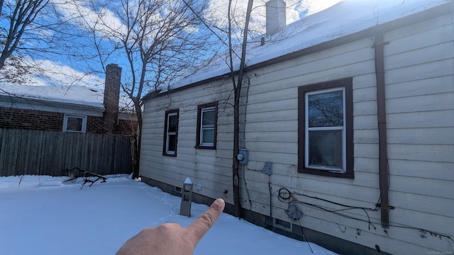 snow covered property featuring fence