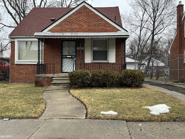 bungalow-style home with a gate, fence, a front lawn, a porch, and brick siding