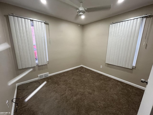 carpeted empty room featuring baseboards, visible vents, and ceiling fan