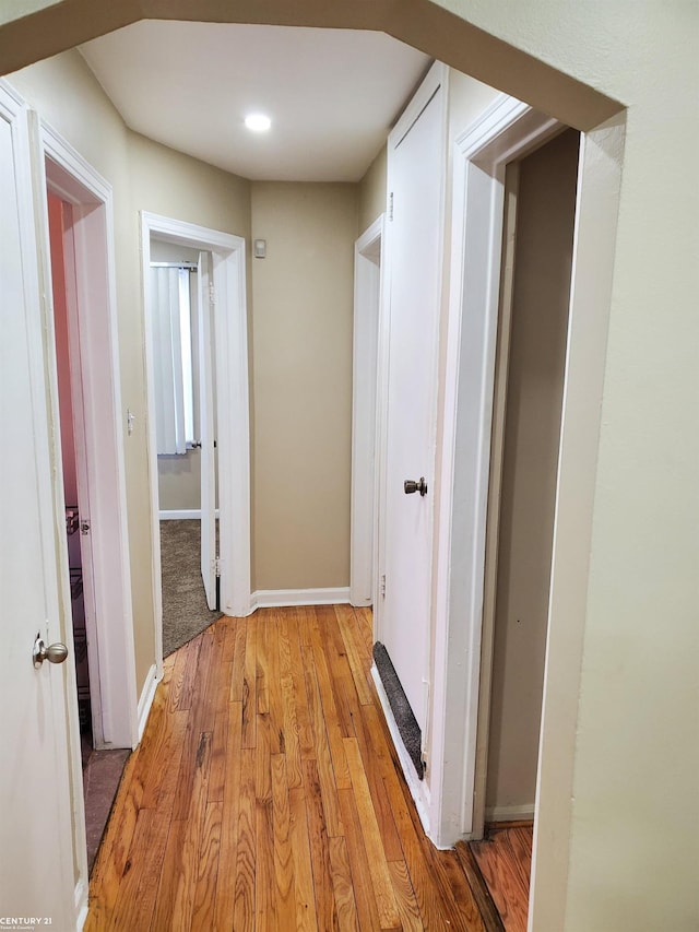 hallway with light wood-style floors and baseboards