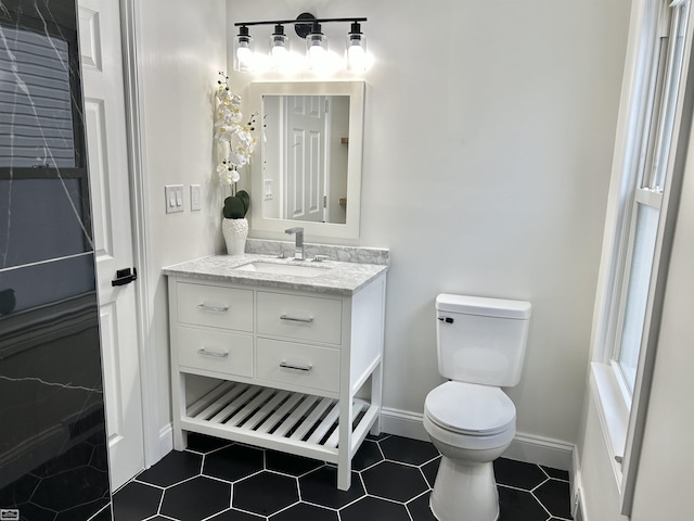 bathroom featuring tile patterned floors, vanity, toilet, and baseboards