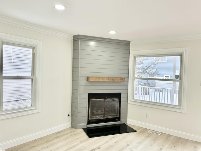 interior details with a fireplace, wood finished floors, visible vents, and baseboards