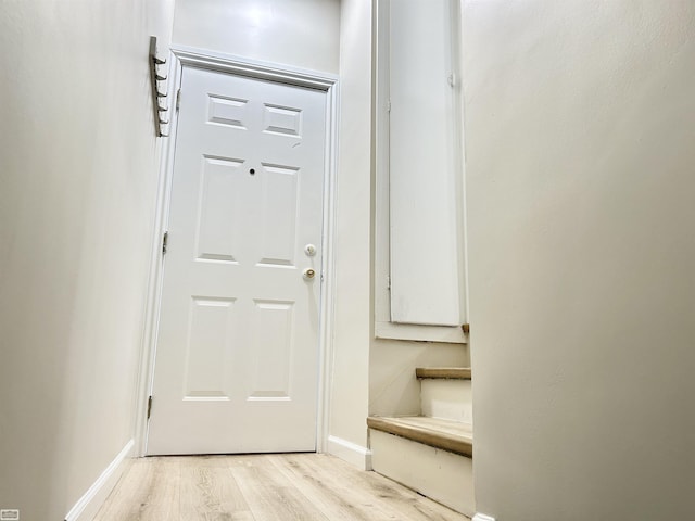 doorway featuring light wood-style floors and baseboards