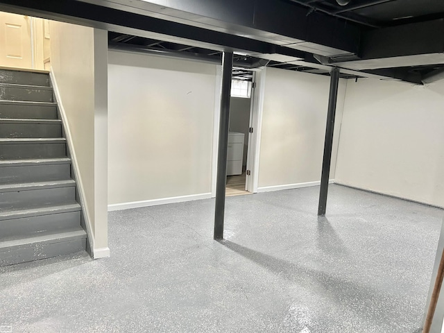 basement with stairs, washer / dryer, and baseboards