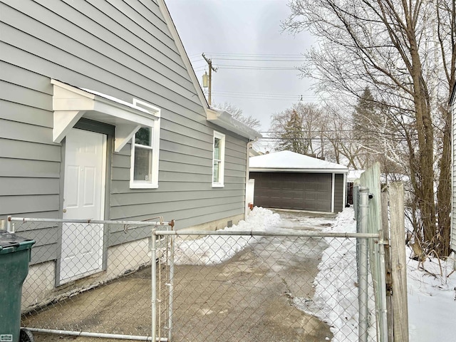 view of side of home featuring a detached garage, fence, and an outdoor structure