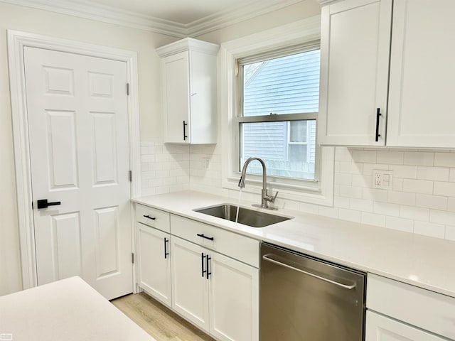 kitchen featuring dishwasher, ornamental molding, a sink, and white cabinetry