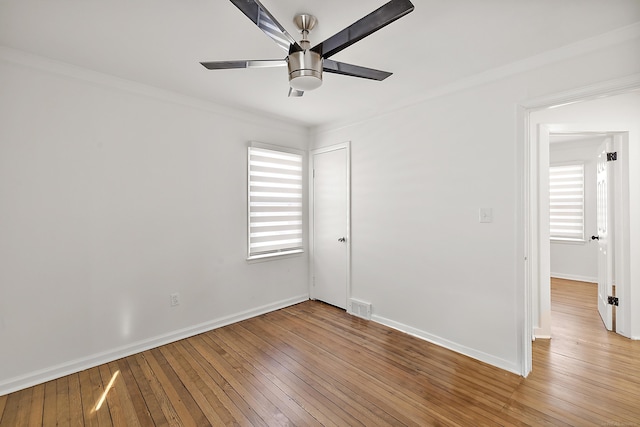 spare room featuring a ceiling fan, a wealth of natural light, visible vents, and light wood finished floors