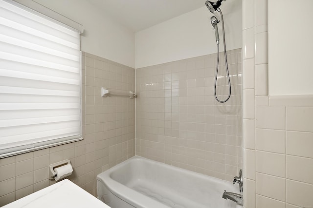 bathroom with tile walls and shower / bathtub combination