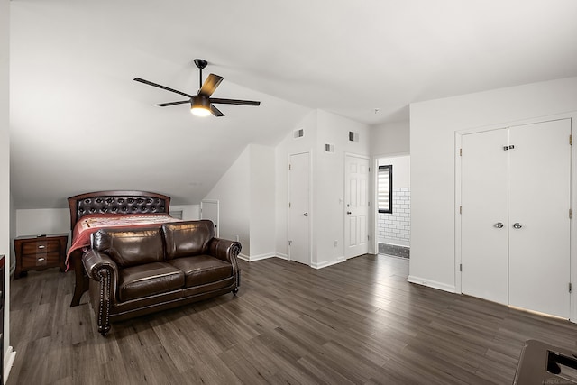 bedroom with dark wood-style floors, baseboards, visible vents, and vaulted ceiling