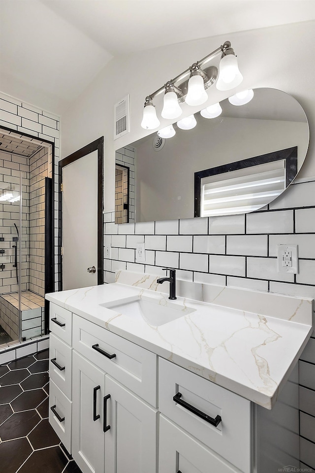 full bathroom featuring tasteful backsplash, lofted ceiling, visible vents, vanity, and tile patterned flooring