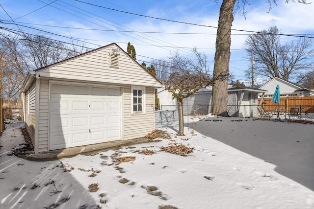 detached garage featuring fence