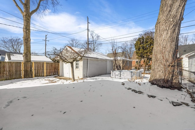 view of yard featuring a detached garage, fence, and an outdoor structure