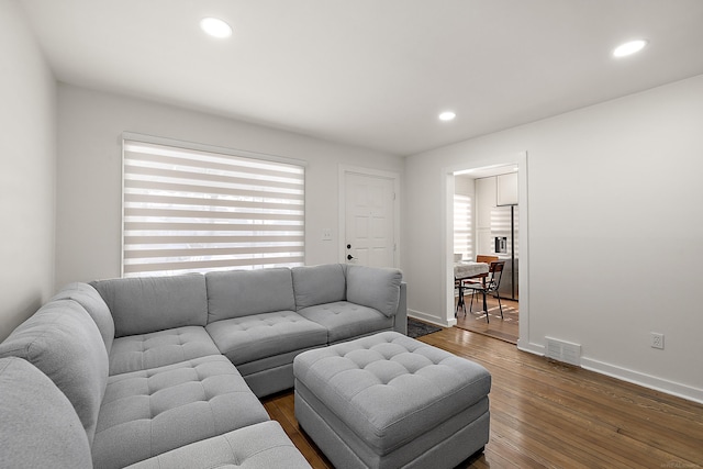 living room featuring baseboards, visible vents, dark wood-style flooring, and recessed lighting