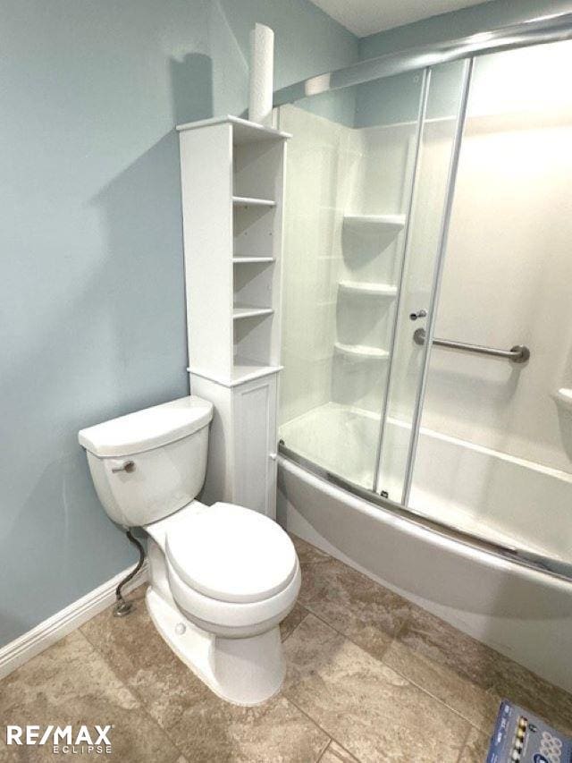 full bathroom featuring baseboards, combined bath / shower with glass door, and toilet