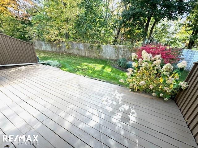 wooden terrace with a yard and a fenced backyard