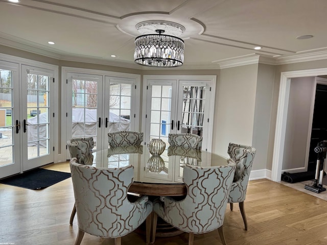 dining space with french doors, a notable chandelier, crown molding, recessed lighting, and light wood-type flooring