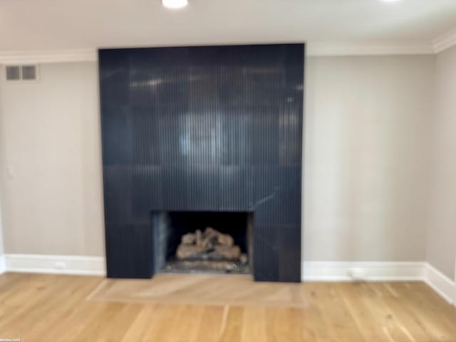 interior space featuring baseboards, wood finished floors, and ornamental molding