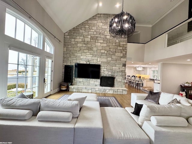 living area featuring high vaulted ceiling, a notable chandelier, crown molding, and wood finished floors