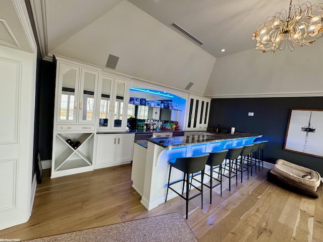 interior space with a notable chandelier, light wood finished floors, lofted ceiling, visible vents, and dishwashing machine