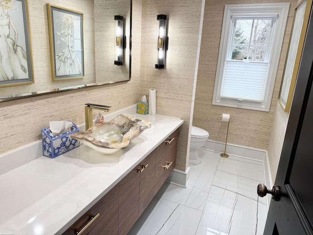 bathroom with toilet, baseboards, and vanity