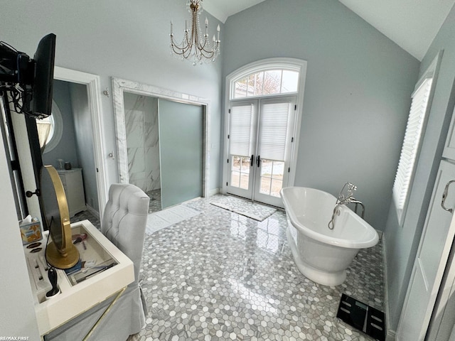 bathroom featuring a freestanding bath, french doors, a chandelier, and a wealth of natural light