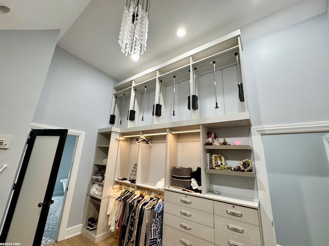 walk in closet featuring a notable chandelier and wood finished floors