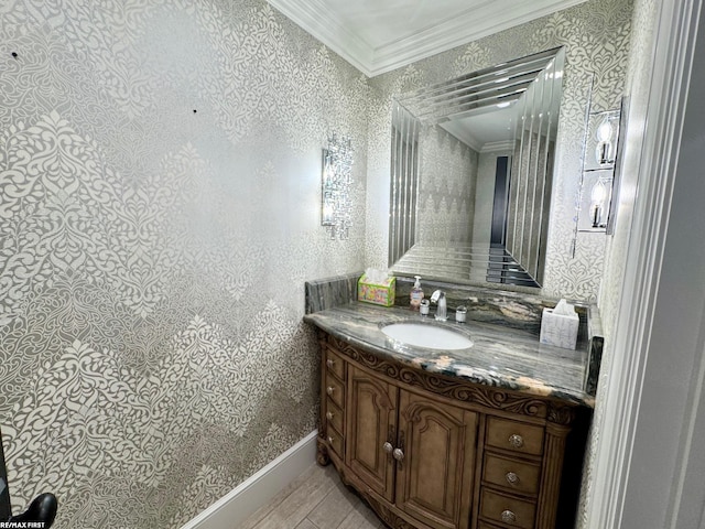 bathroom featuring crown molding, baseboards, vanity, and wallpapered walls