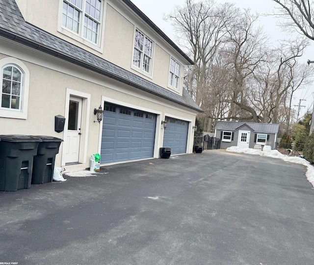 view of property exterior with a garage, a shingled roof, and stucco siding