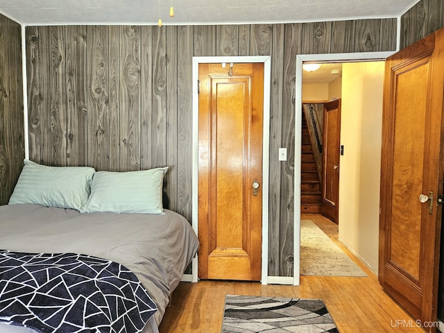 bedroom featuring light wood-type flooring and wood walls