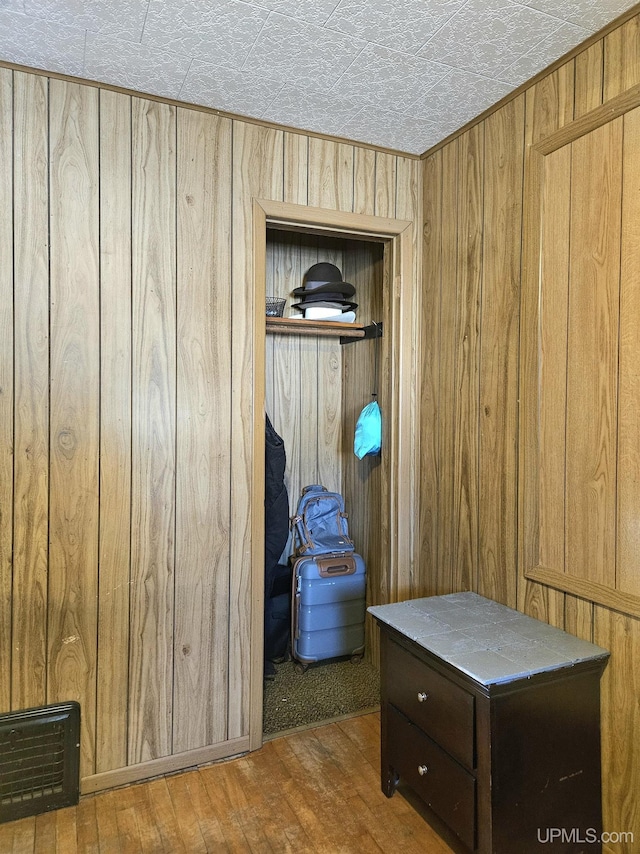 interior space with wood walls, wood finished floors, and visible vents