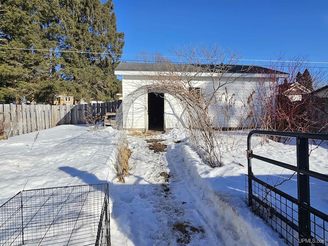 snow covered structure featuring fence