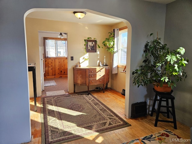 entrance foyer with arched walkways and hardwood / wood-style flooring