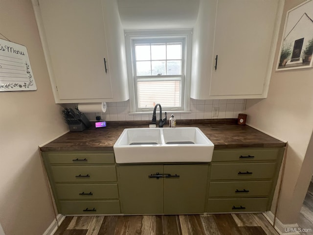 kitchen with dark wood-style floors, decorative backsplash, green cabinets, and a sink