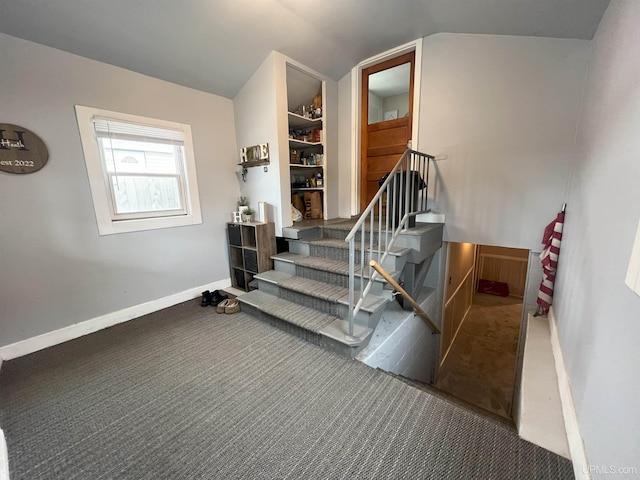 stairs featuring vaulted ceiling, carpet, and baseboards